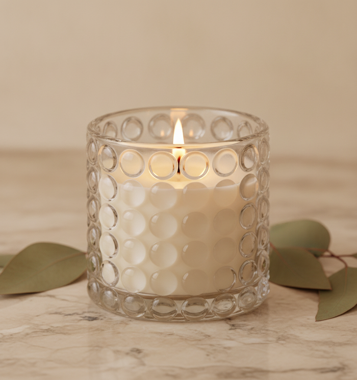 Envase oscuro de aspecto mineral con vela